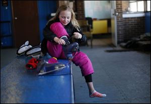 Sydney Mack, 9, takes off her skates at Ottawa Park ice rink on the last day of the season. With the city slashing the rink’s budget by more than half from last year, the rink may not reopen in November.
