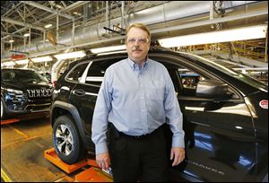 Chuck Padden, plant manager for the Toledo Assembly complex, stands in front of the line of completed Jeep Cherokees. The plant is currently assembling 990 Cherokees per day. 