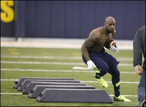 Running back  David Fluellen takes part in a drill at the University of Toledo’s pro day on Monday. Representatives from at least 18 NFL teams attended the event. Several ex-Rockets took part.