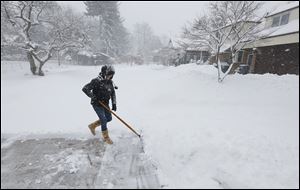 Wendy Hayes shovels snow at her Old Orchard home Wednesday. Area school districts have pondered how to make up a bevy of days missed because of snow.