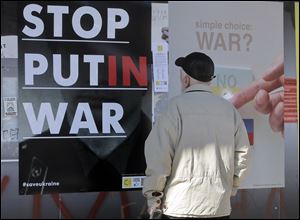 A man looks at the posters during the International poster campaign to support Ukraine in center Kiev, Ukraine, today.