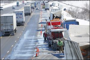 Traffic inches by while crews work to clean the remains of a multi-vehicle accident in the eastbound lane of the Ohio Turnpike on Thursday near the County Road 268 overpass near Clyde.