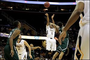 Toledo's Julius Brown (20) puts up a three point field goal as Eastern Michigan's Lee Raven (0) attempts to block in the first half.