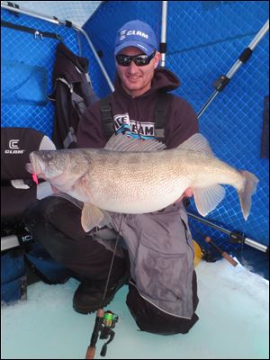 Ross Robertson holds a 13-pound walleye he took through the ice this week while fishing on Lake Erie.