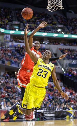 Michigan’s Caris LeVert gets by Ohio State’s Shannon Scott to put up a shot in the first half. The sophomore from Pickerington, Ohio, scored 17 points to help send the Wolverines into today’s Big Ten title game against Michigan State.
