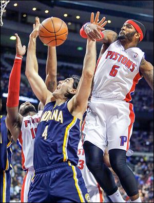 Detroit’s Josh Smith blocks a shot by Indiana’s Luis Scola as Greg Monroe, left, helps out.