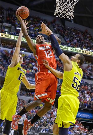 Ohio State’s Sam Thompson slices between Michigan’s Nik Stauskas, left, and Jordan Morgan. Thompson scored 11 points but fouled out. Morgan also fouled out.