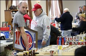 Monroe, Mich. resident Jay Heinzerling carries around a Budweiser Pistons mirror to trade or sell during the 40th Annual Buckeye Beer and Mancave Show at the UAW Hall in Toledo.