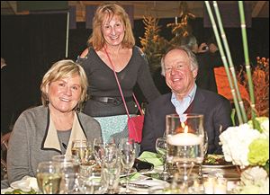 President of the Board of Directors at the Toledo Zoo, Mary Ellen Pisanelli, center, visits the table of Ann and John Meier.
