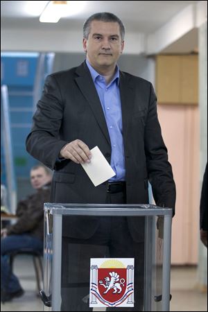 The head of Crimea's unrecognised Russian-backed government Sergei Aksyonov goes to cast his ballot at a polling station Sunday in Simferopol, Ukraine.