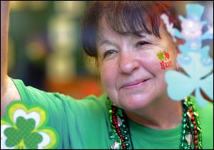 Alice Linley takes a breaks from her job as a waitress at Clarys restaurant to wave at people waiting for Savannah's 190-year-old St. Patrick’s Day parade to start, today, in Savannah, Ga.