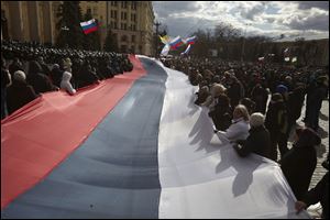 Pro-Russia demonstrators chant slogans as they carry a giant flag during a rally at a central square in Kharkiv, Ukraine, to show their support for the Crimean referendum Sunday.