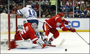 Detroit Red Wings goalie Jimmy Howard (35) stops a Toronto Maple Leafs right wing Joffrey Lupul (19) shot as defenseman Danny DeKeyser defends.