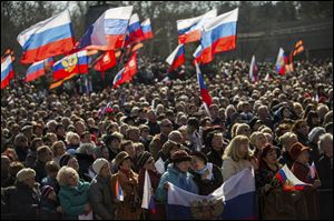 People gather at a square to watch a televised address by Russian President Vladimir Putin to the Federation Council, in Sevastopol, Ukraine today.