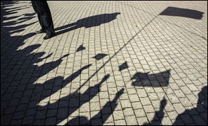 People cast shadows waving flags as they gather at a square to watch a televised address by Russian President Vladimir Putin to the Federation Council, in Sevastopol, Crimea, Tuesday.