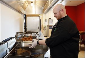 Mud Hens chef Dusten Brown prepares Chicken and Waffle Bites for a food-tasting event.