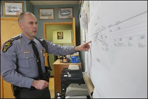 Highway Patrol Lt. Brett Gockstetter, Milan post commander, explains a crash reconstruction schematic from the multivehicle accidents on March 12 in the eastbound lanes of the Ohio Turnpike near Clyde, Ohio.