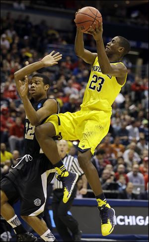 Michigan guard Caris LeVert (23) drives to the basket over Wofford guard Spencer Collins (32) during the second half today in Milwaukee.