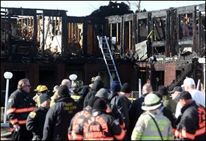 Firefighters investigate an early morning fire at the Mariner's Cove Hotel in Point Pleasant Beach, N.J. today. At least three people were killed at the hotel whose residents included Superstorm Sandy victims whose homes were destroyed in the hurricane.