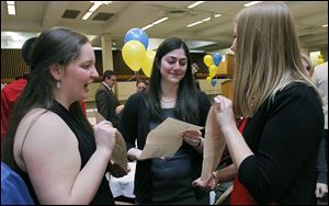 University of Toledo fourth-year medical students Pamela Glennon, Madeline Heald, and Alexandra Paraskos, from left, show each other their letters during the annual Residency Match reception at the Stranahan Theater's Great Hall in South Toledo.