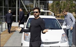 Google co-founder Sergey Brin gestures after riding in a driverless car in 2012 at Google headquarters. While most investors aren’t worried about the experiments, experts point out that Google X has yet to produce a major economic hit.