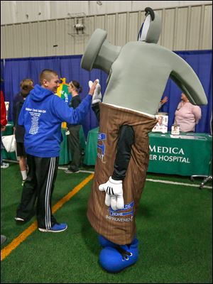 Above, dancers from Toledo-based El Cora­zon de Mex­ico Bal­let Folk­lor­ico perform at the annual Showcase Sylvania Expo at Tam-O-Shanter.Left, Sylvania resident Dominic Arvay, 16, high-fives the mascot of Arnold’s Home Improvement.