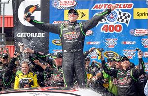 Kyle Busch celebrates as his team drenches his wife, Samantha Busch, left, in victory circle after his win. 