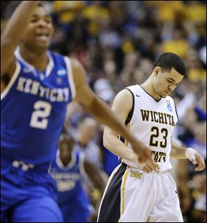 Wichita State guard Fred VanVleet, right, leaves the floor after missing a 3-point attempt in the final seconds against Kentucky on Sunday in St. Louis. Kentucky won 78-76.