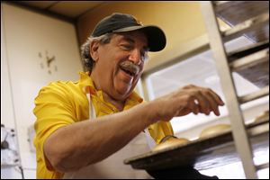 Barry Greenblatt, owner of Barry Bagels, removes bagels from the oven at his store in Sylvania. He’s been in the business since 1972. 