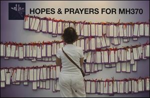 A woman read message cards tied up for passengers aboard a missing Malaysia Airlines plane, at a shopping mall in Kuala Lumpur, Malaysia, today.