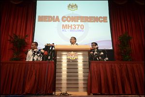 Malaysia's acting Transport Minister Hishammuddin Hussein, center, answers questions, accompanied by Malaysia Airlines CEO Ahmad Jauhari Yahya, left, and Malaysia's Department of Civil Aviation Director General Azharuddin Abdul Rahman today at Putra World Trade Center in Kuala Lumpur, Malaysia.