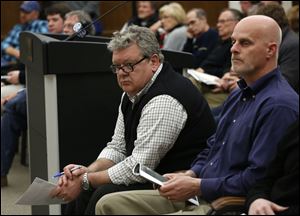 Costco representative Ted Johnson, left, listens to comments from the City Council during a special meeting. To his right is Perrysburg city council member James Matuszak, who declared a conflict of interest and did not vote.
