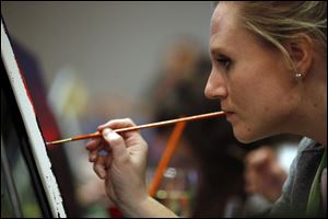 Meg Shollenberger, of Philadelphia, paints during a Paint Nite event at the Field House sports bar in Philadelphia Tuesday.