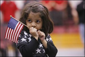 Aashna Lalla, 3, watches as her father, Anish Lalla, originally from India, becomes a U.S. citizen.