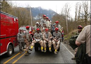 National Guard troops prepare to enter the mudslide debris on the western edge of the mudslide where it covers Highway 530 early Wednesday morning.