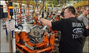 John Wooten places pistons into the new 2.7-liter EcoBoost engine on the assembly line  at Ford’s Lima Engine Plant Friday. Production of the twin-turbo-charged engine designed specifically for the F-150 pickup is expected to begin this fall.