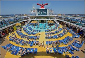 Vacationers aboard the Carnival Breeze sunbathe while viewing a movie on a 270-square-foot screen. Lines are looking for ways to lure the 200 million Americans who have never taken a cruise.