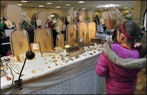 Kamryn Phillips, 11, and her aunt Lynn Witte look at jewelry from the Spare Parts booth. The free event at Lourdes University is part of its celebration of National Women’s History Month and recognizes women in the visual and performing arts through a juried show and sale.