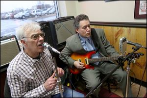Tim Healy, left, sings while Art Schlosser, both of West Toledo, right, plays as the pair preform at the Maumee restaurant Deet's BBQ. Healy and Schlosser make up the duet Slim & Slam.
