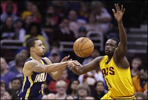 Indiana's George Hill, left, passes against Cleveland Cavaliers defender Luol Deng during the second quarter Sunday in Cleveland.