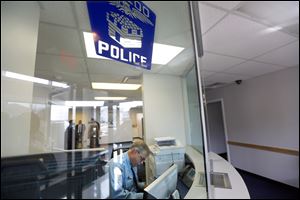 Officer James Mawer works the front desk at the newly reopened Toledo Police Department’s Northwest District Substation. City leaders applauded the reopening Monday during a ribbon-cutting ceremony.