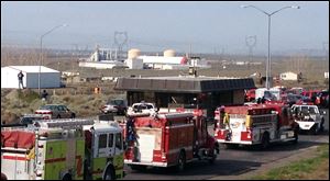 A line of emergency vehicles line a roadway in sight of the Williams Northwest Pipeline plant in the distance today in Plymouth, Wash. 