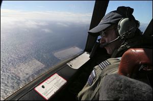 Royal New Zealand Air Force P-3 Orion's captain, Wing Comdr. Rob Shearer watches out of the window of his aircraft while searching for the missing Malaysia Airlines Flight MH370 in the southern Indian Ocean, Monday.