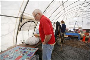 David Bush, chairman of the Friends and Descendants of Johnson Island Civil War Prison, works inside  the weather tent to prepare for Saturday's ‘Park Day,’ an event in which volunteers will help clean up the Civil War prison site.