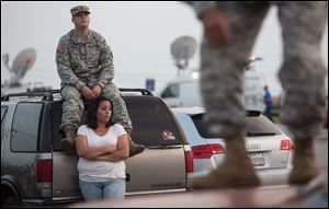 Lucy Hamlin and her husband, Spc. Timothy Hamlin, wait for permission to re-enter the Fort Hood military base, where they live, following a shooting on base on Wednesday.