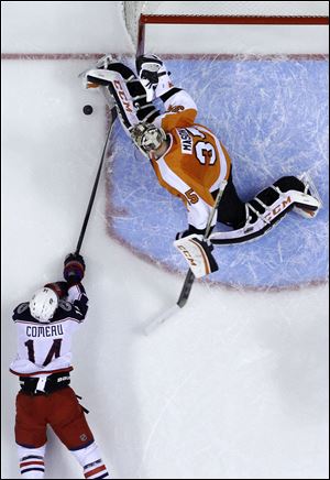 Columbus Blue Jackets' Blake Comeau, left, tries to get a shot past Philadelphia Flyers goalie Steve Mason during the first period Thursday in Philadelphia.