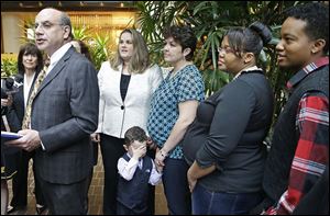 Attorney Al Gerhardstein, left, stands with several same-sex couples at a news conference Friday in Cincinnati. Mr. Gerhardstein said ‘this [gay marriage ban] is a serious problem at the basic level of human dignity.’