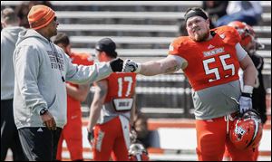Bowling Green coach Dino Babers fist bumps lineman Alex Huettel. The offense averaged about two plays per minute in Saturday’s spring game at Perry Stadium as 11 receivers caught passes.