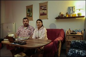 Michael Guhle and his wife Thi An Nguyen from Vietnam sit in their apartment at the Weissensee district in Berlin, Germany. 