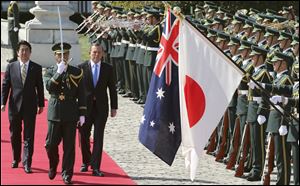 Australian Prime Minister Tony Abbott, center, reviews an honor guard during a welcome ceremony with Japanese Prime Minister Shinzo Abe, left, at Akasaka State Guest House in Tokyo  today. Abbott is on a four-day official visit. 